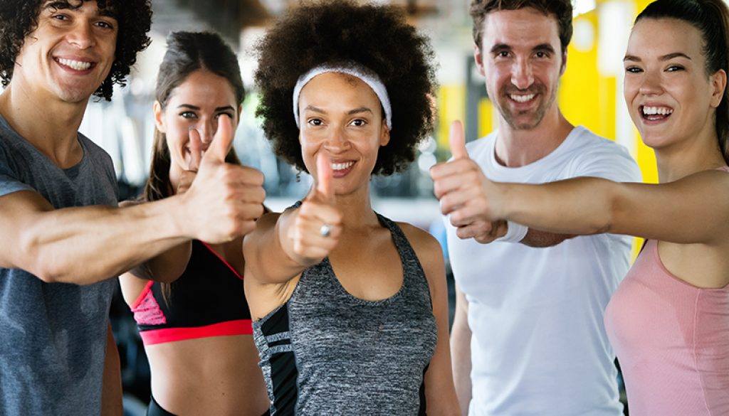 five happy people give the thumbs up as they begin their workout at the gym Colorado TMS